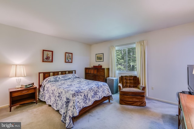 bedroom featuring baseboards and light carpet