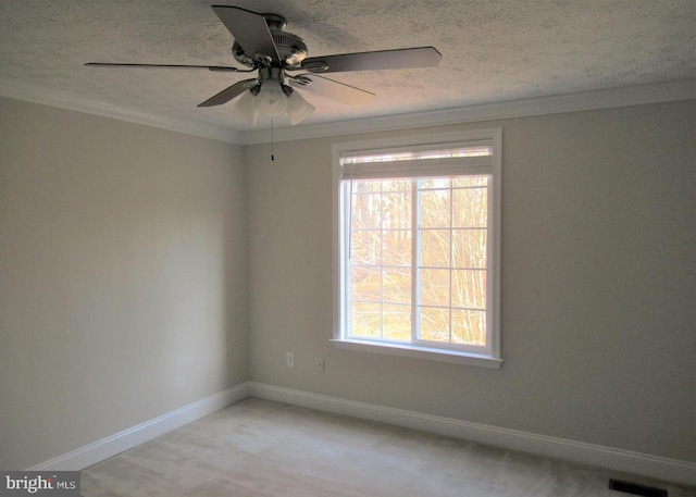 unfurnished room featuring plenty of natural light, a textured ceiling, a ceiling fan, and visible vents