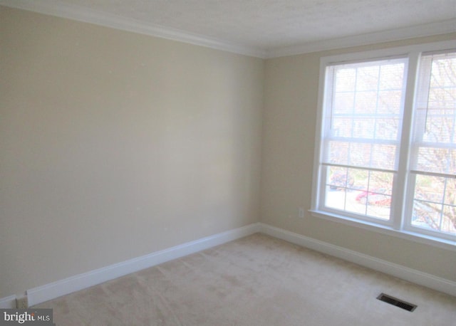 unfurnished room with plenty of natural light, baseboards, visible vents, and ornamental molding