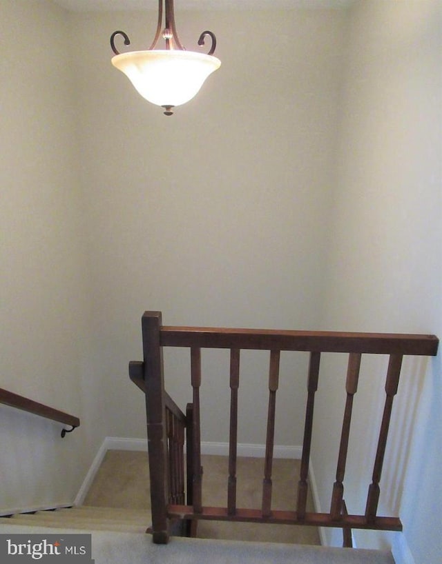 staircase featuring carpet floors and baseboards