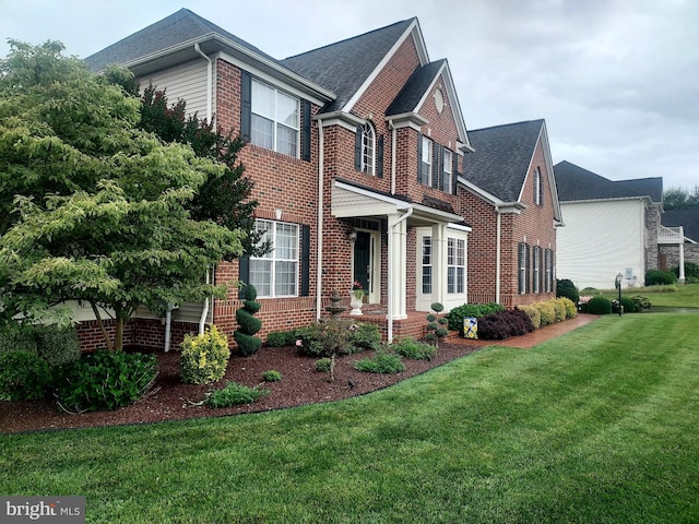 view of home's exterior with brick siding, a yard, and a shingled roof