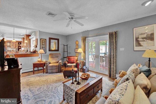 living room featuring wood finished floors, ceiling fan, a baseboard radiator, and baseboards