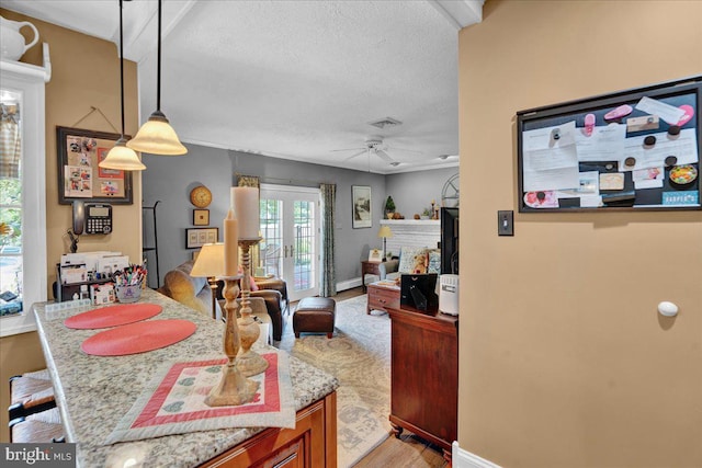 dining space with ceiling fan, light wood-type flooring, a textured ceiling, and baseboards