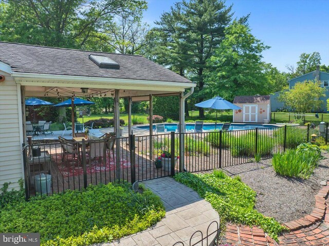 view of yard with fence, an outbuilding, a shed, and a patio