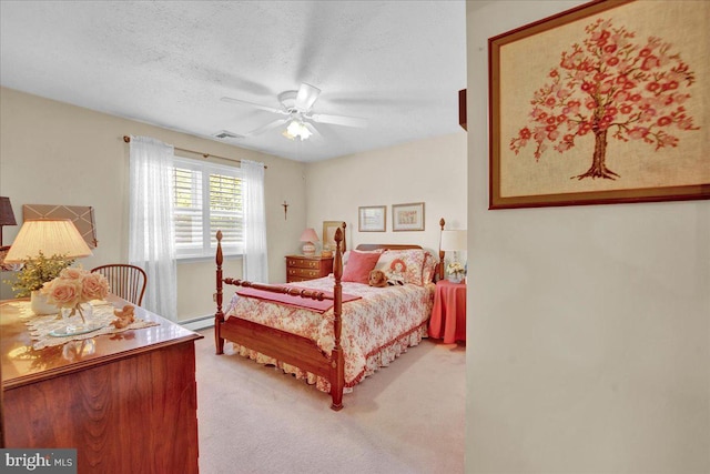 bedroom with light colored carpet, baseboard heating, a textured ceiling, and a ceiling fan
