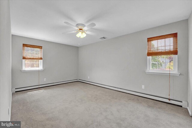 unfurnished room featuring healthy amount of natural light, a ceiling fan, carpet, and a baseboard radiator