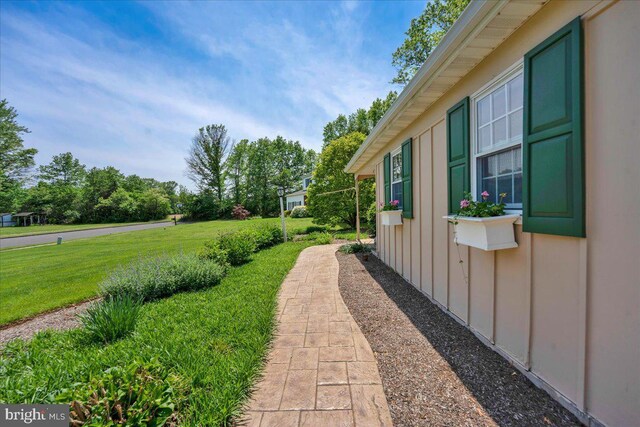 view of side of home with board and batten siding and a lawn