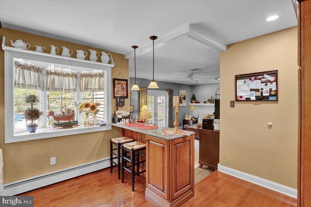 bar featuring baseboard heating, a ceiling fan, baseboards, light wood finished floors, and a fireplace