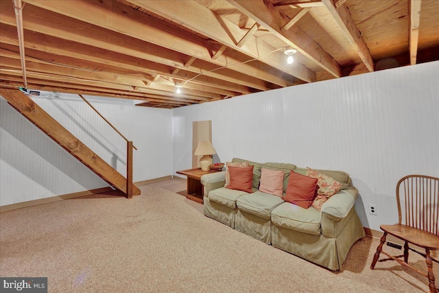carpeted living area with stairway and baseboards