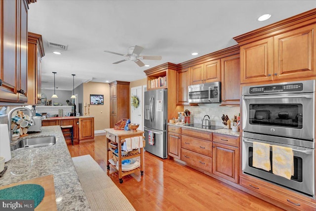 kitchen with stainless steel appliances, a sink, decorative backsplash, a ceiling fan, and recessed lighting