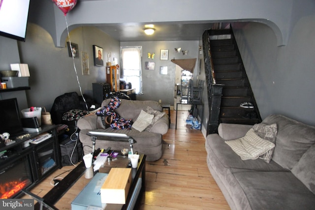 living room featuring wood finished floors and stairway