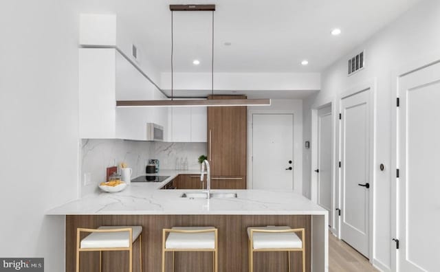 7700 Georgia Ave NW Unit 303, Washington, DC 20012 - kitchen with recessed lighting, a peninsula, backsplash, visible vents, and a sink
