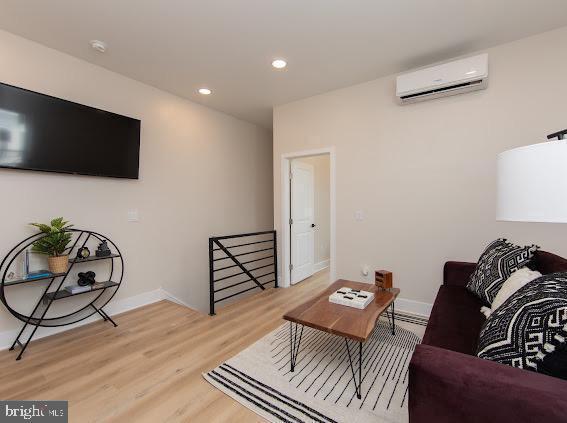 2001 S Norwood St, Philadelphia, PA 19145 - living room with a wall mounted air conditioner, recessed lighting, light wood finished floors, and baseboards