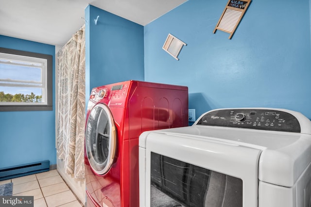 laundry room with washing machine and clothes dryer, tile patterned floors, a baseboard heating unit, and laundry area