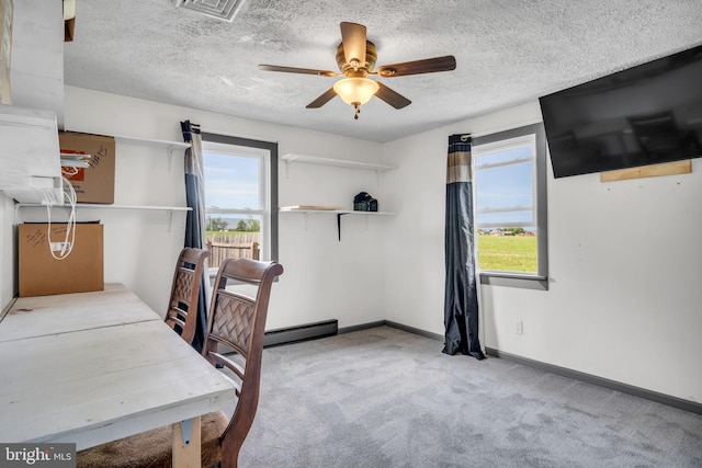carpeted office space with visible vents, a ceiling fan, a textured ceiling, and baseboards