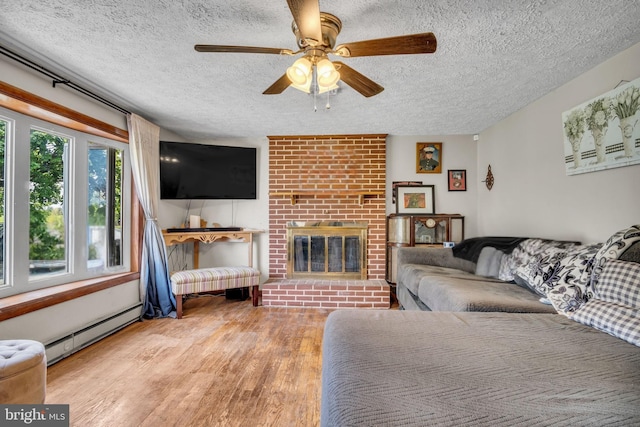 living room with a baseboard radiator, a ceiling fan, a textured ceiling, and wood finished floors