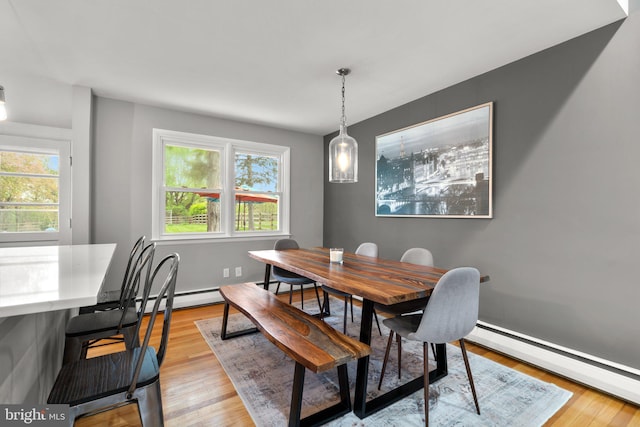 dining room with light wood finished floors, baseboards, and a baseboard radiator