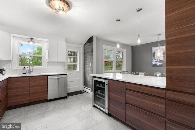 kitchen featuring stainless steel dishwasher, a sink, beverage cooler, light countertops, and modern cabinets