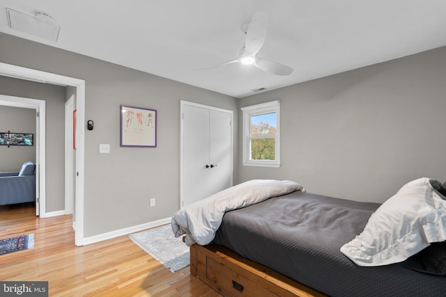 bedroom with ceiling fan, visible vents, a closet, baseboards, and light wood-type flooring