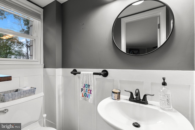half bath featuring toilet and a sink