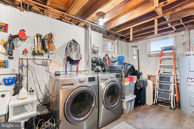 laundry area with concrete block wall, water heater, wood finished floors, and laundry area