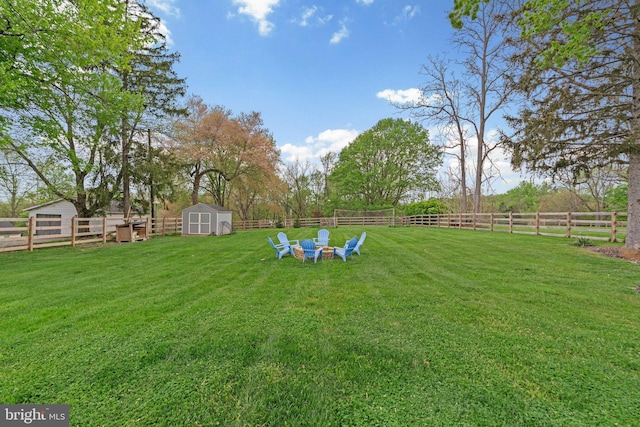 view of yard featuring a storage unit, a fenced backyard, and an outdoor structure