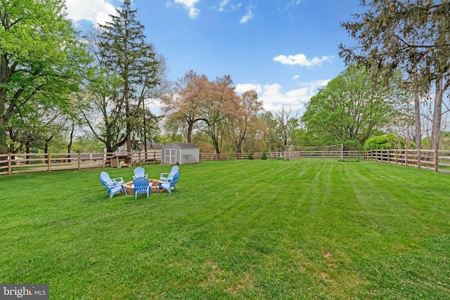 view of yard with an outdoor structure, a storage unit, and a fenced backyard