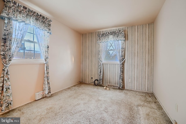 carpeted spare room featuring wallpapered walls