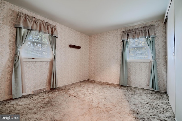 carpeted spare room with wallpapered walls