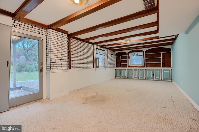 carpeted empty room featuring beamed ceiling, baseboards, and visible vents