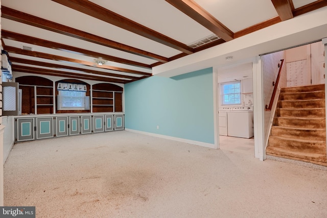 unfurnished living room with washer and dryer, visible vents, stairs, and beamed ceiling