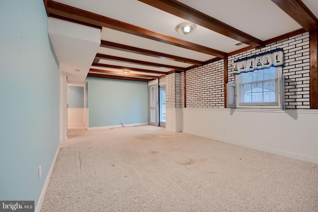 empty room featuring plenty of natural light, baseboards, carpet flooring, and beam ceiling