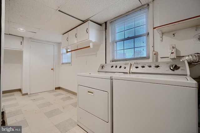 clothes washing area featuring light floors, washing machine and dryer, baseboards, and laundry area