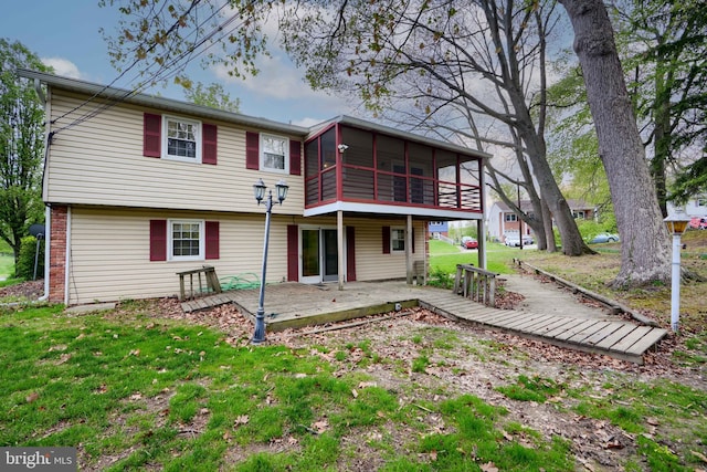 rear view of property with a deck, a sunroom, a yard, and a patio