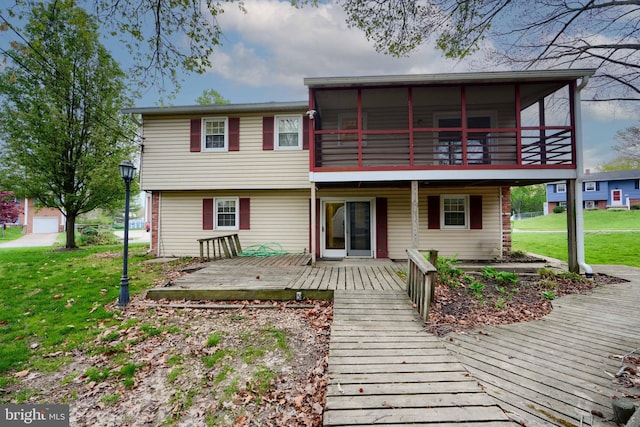 townhome / multi-family property with a wooden deck, a sunroom, and a front yard