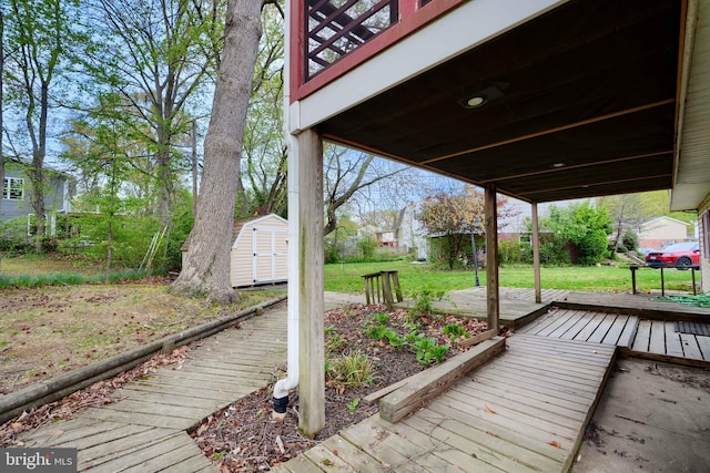 deck with a storage shed, a yard, and an outbuilding