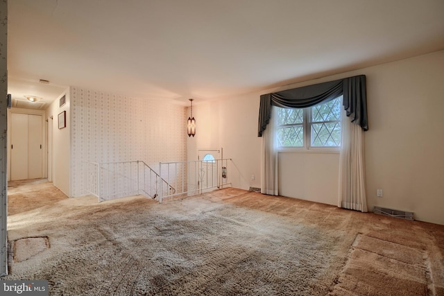 empty room with carpet flooring and visible vents