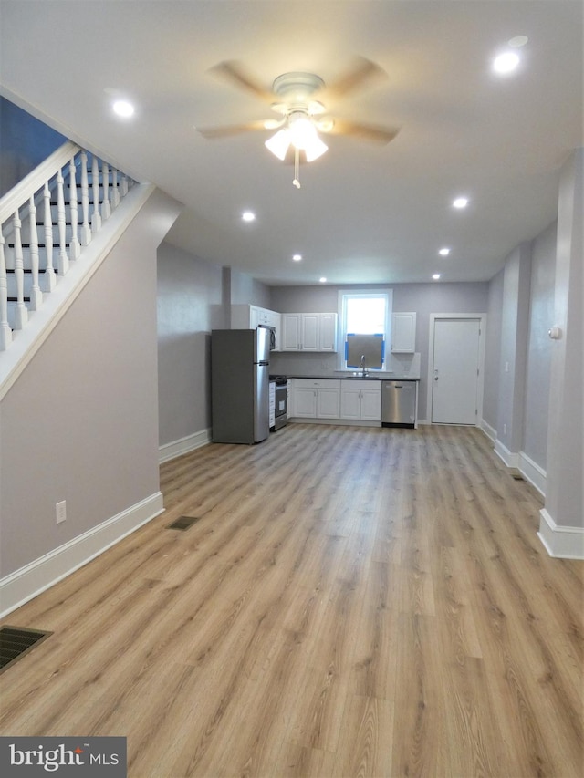 2147 W Grange Ave, Philadelphia, PA 19138 - unfurnished living room with light wood-style flooring, a sink, a ceiling fan, and baseboards