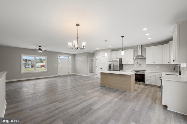 309 Gun Club Rd, Stephenson, VA 22656 - kitchen with a center island, a sink, wall chimney range hood, open floor plan, and appliances with stainless steel finishes