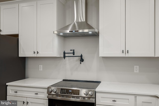 309 Gun Club Rd, Stephenson, VA 22656 - kitchen with white cabinetry, freestanding refrigerator, wall chimney exhaust hood, and electric stove
