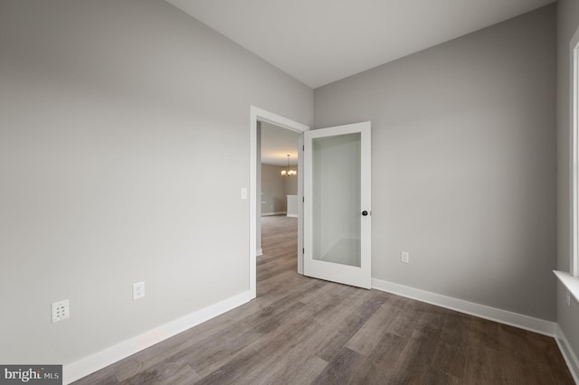 309 Gun Club Rd, Stephenson, VA 22656 - empty room with wood finished floors, a notable chandelier, and baseboards