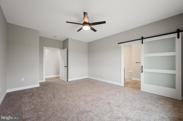 309 Gun Club Rd, Stephenson, VA 22656 - unfurnished bedroom with baseboards, connected bathroom, carpet, and a barn door
