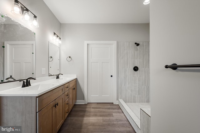 309 Gun Club Rd, Stephenson, VA 22656 - full bathroom featuring double vanity, a tile shower, a sink, and wood finished floors