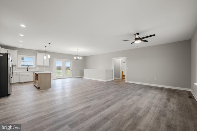 309 Gun Club Rd, Stephenson, VA 22656 - unfurnished living room with baseboards, light wood finished floors, recessed lighting, and ceiling fan with notable chandelier