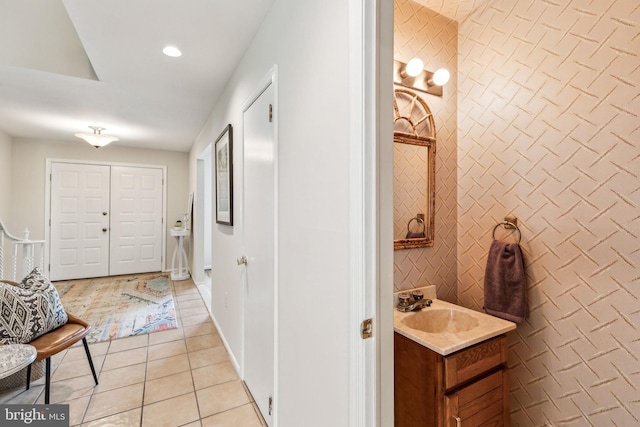 hallway with a sink, light tile patterned flooring, and recessed lighting