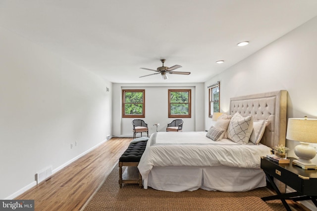 bedroom with wood finished floors, a ceiling fan, visible vents, baseboards, and recessed lighting