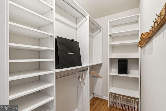 walk in closet with wood finished floors