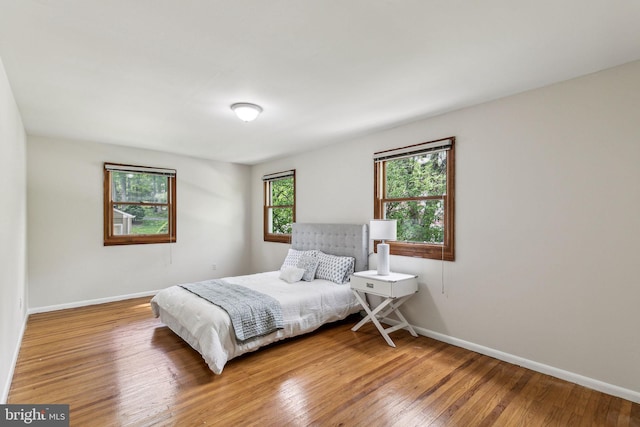 bedroom with wood-type flooring and baseboards