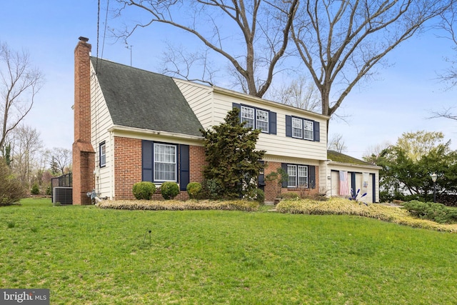 colonial inspired home with roof with shingles, a chimney, a front lawn, brick siding, and central AC unit