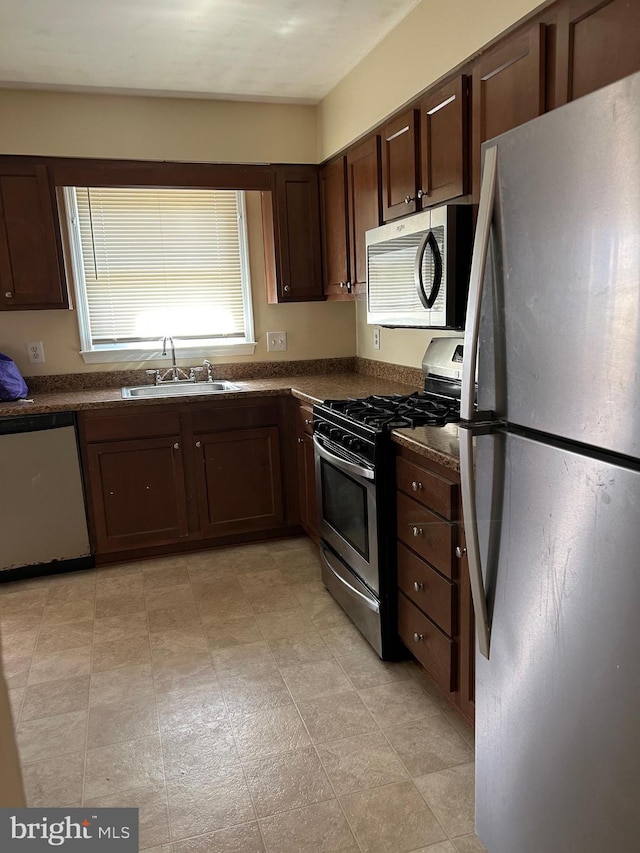 4913 Odell Rd, Beltsville, MD 20705 - kitchen featuring dark brown cabinetry, appliances with stainless steel finishes, a sink, and dark countertops